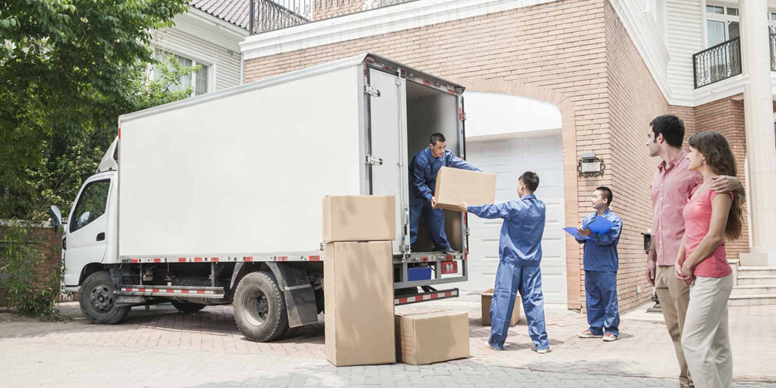 Couple watching while a team moves their boxes to truck