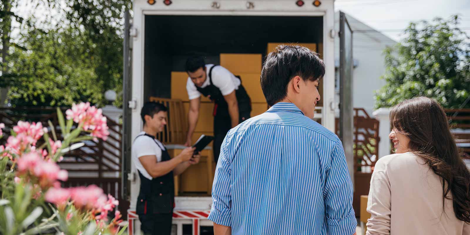Couple looking at each other while a team moves their boxes